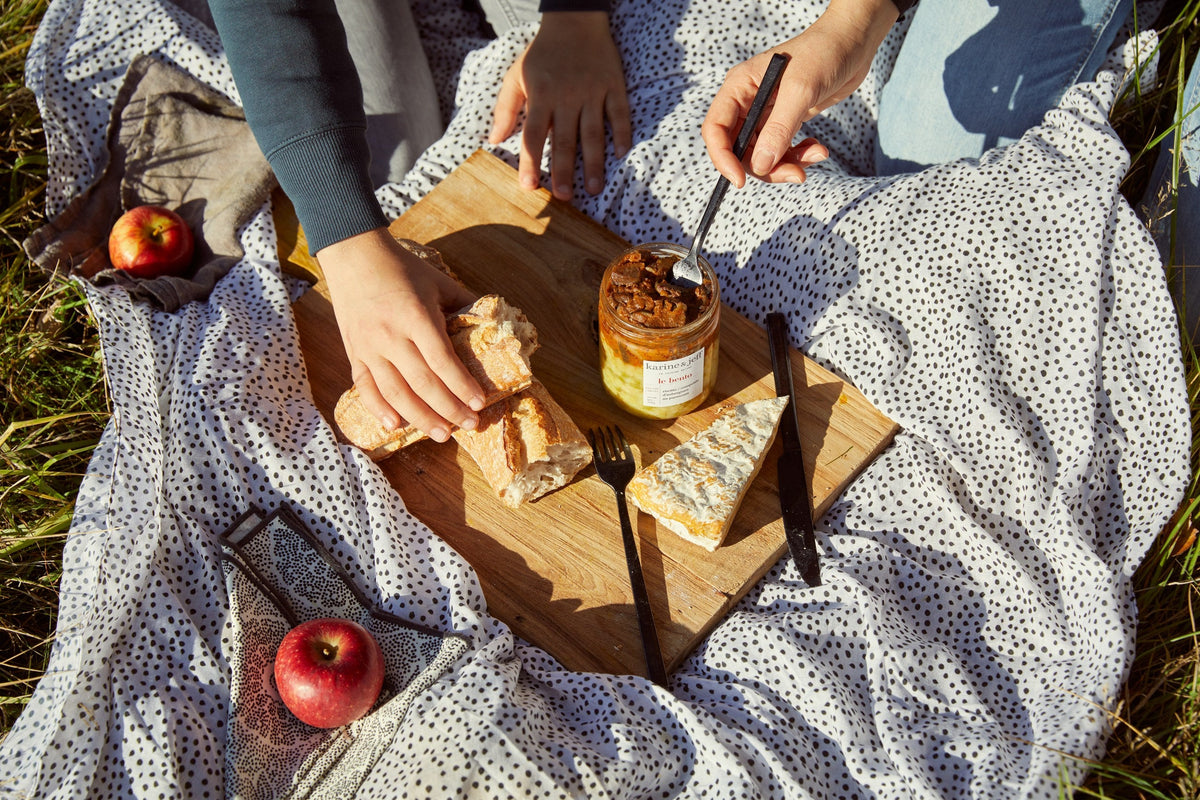 Planche de pain, fromage et bocal ouvert sur une nappe, pique-nique d'automne Image