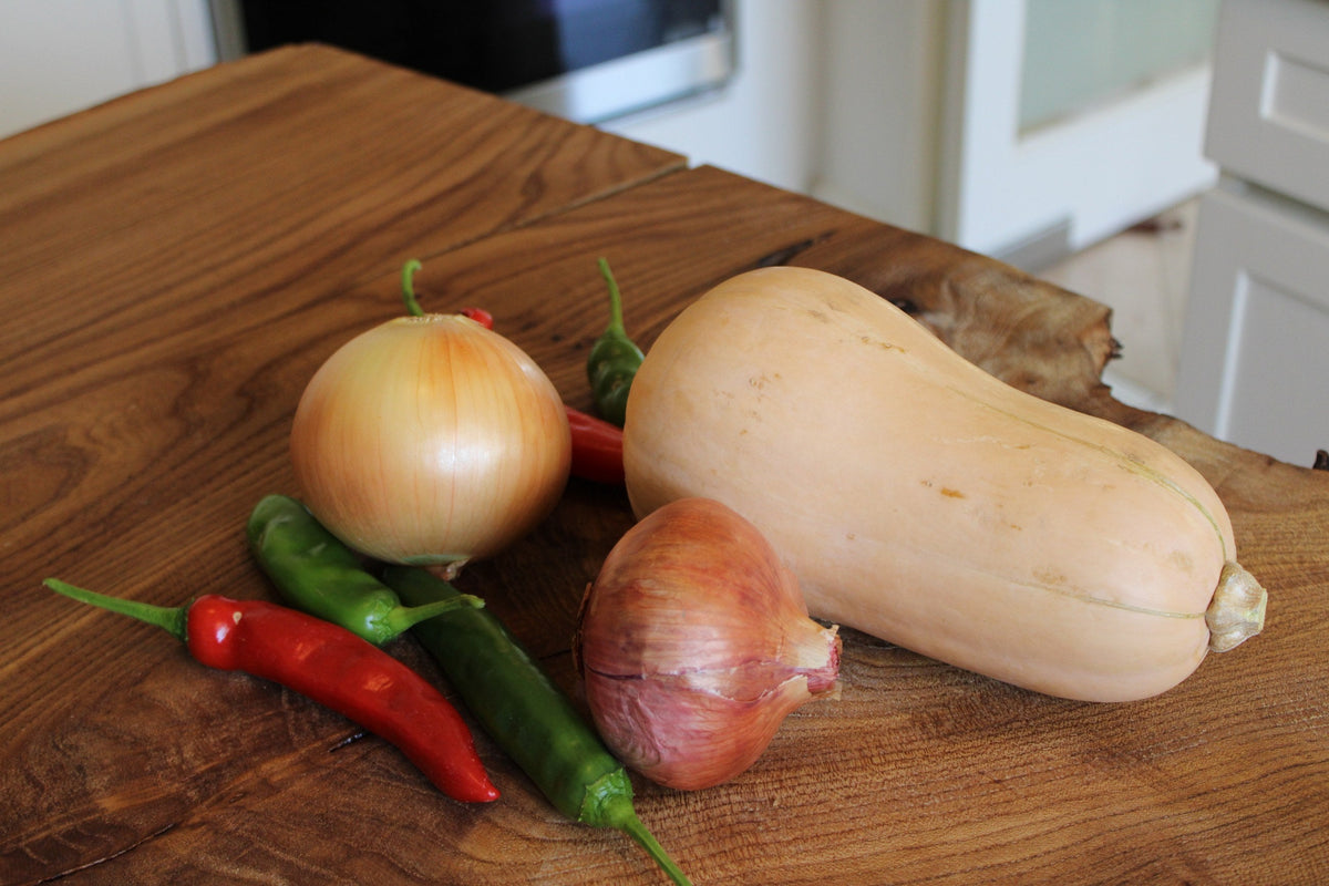 Courge butternut, oignons et piments sur une planche en bois Image