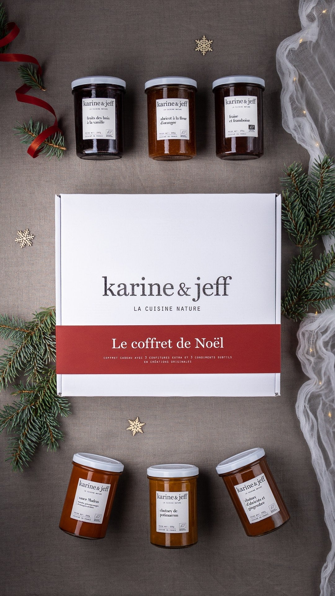 Coffret de Noël Karine & Jeff entouré de bocaux et de branches de sapin Image